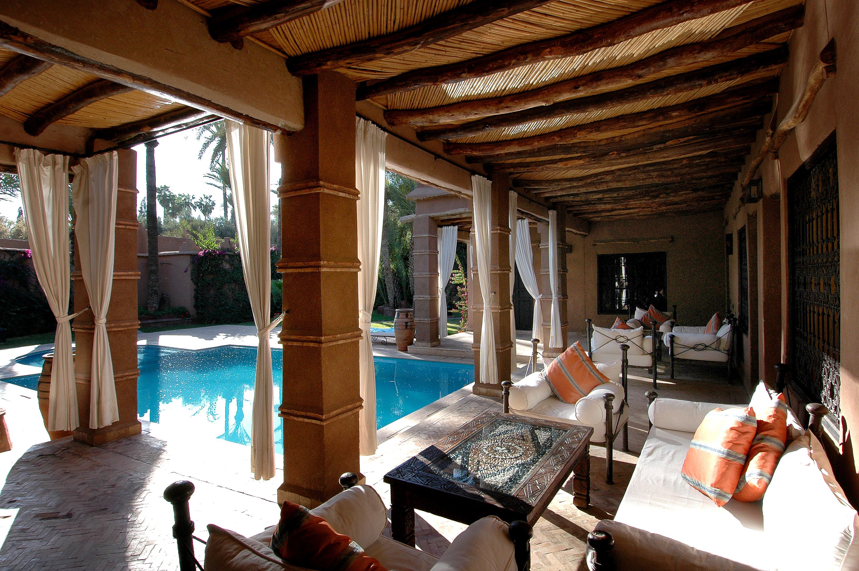 Elegant outdoor lounge with soft seating overlooking a serene swimming pool